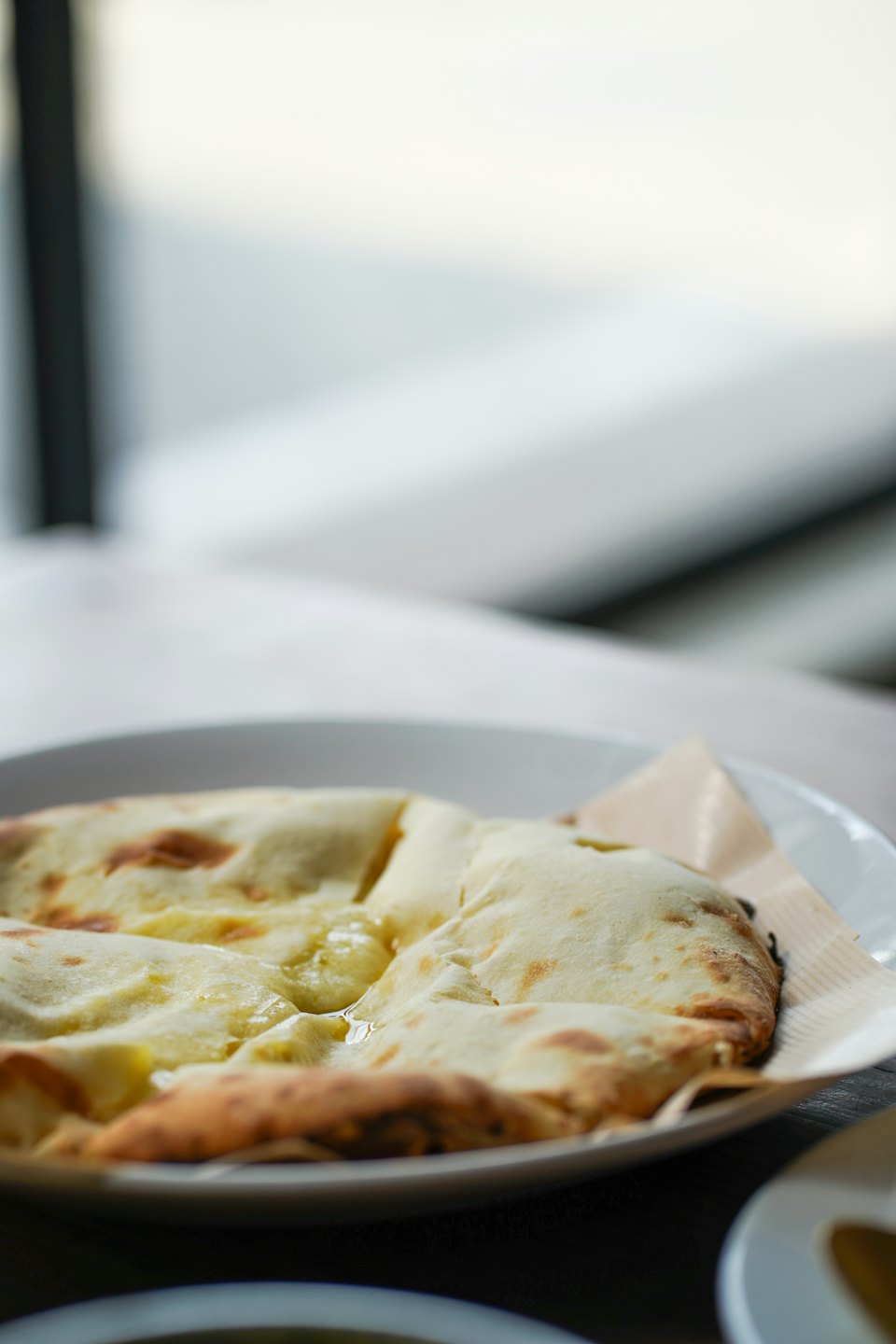 Pan naan con mantequilla brillante en un plato blanco.
